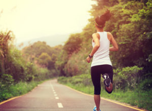 young fitness woman runner running at forest trail